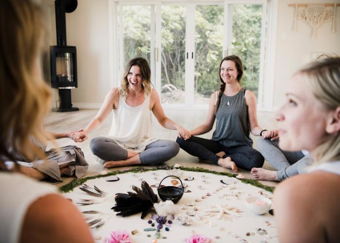 Mujeres en círculo de meditación compartiendo energía y unión espiritual